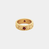 Gold ring with red gemstones on a white background