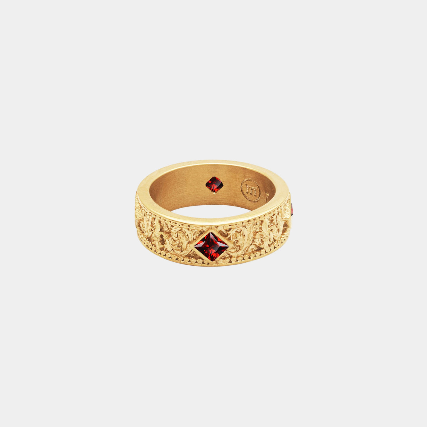 Gold ring with red gemstones on a white background