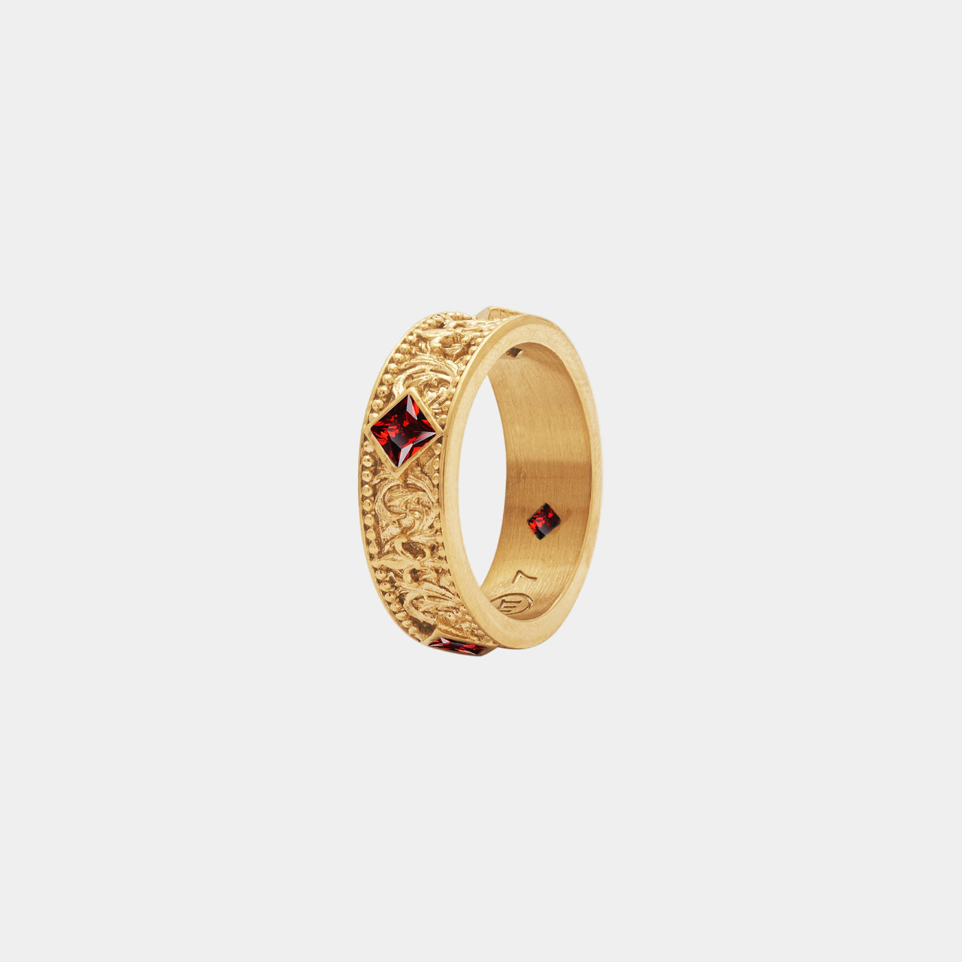 Gold ring with red gemstones on a white background